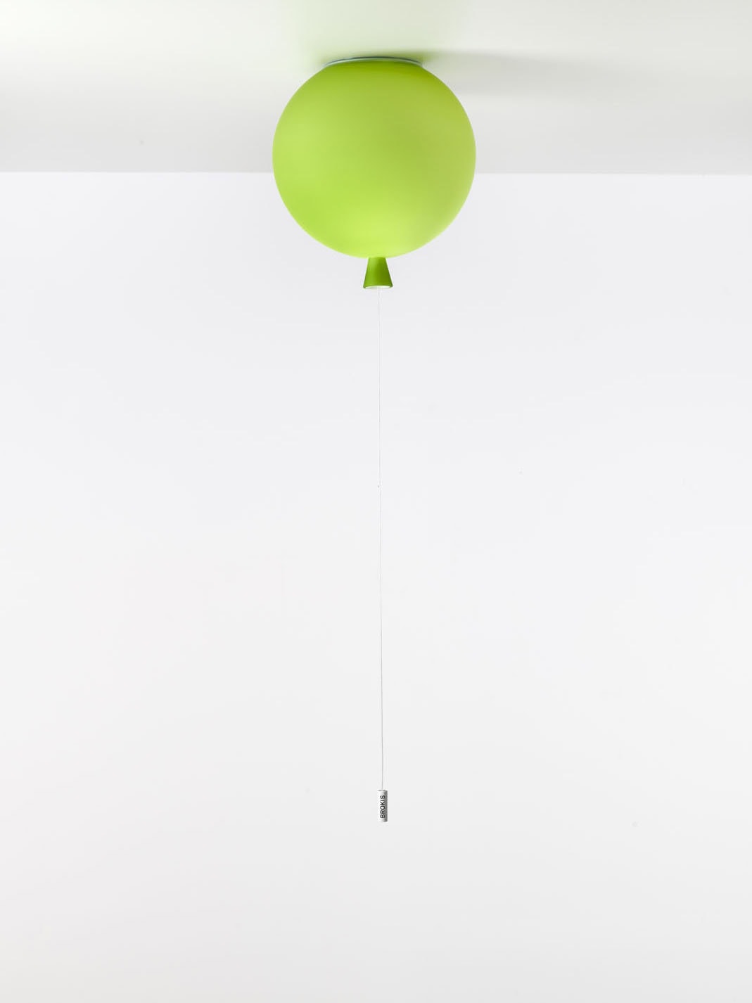 Brokis Memory Ceiling 250, a sculptural green light, floats against a white ceiling, anchored by a refined glossy weight.
