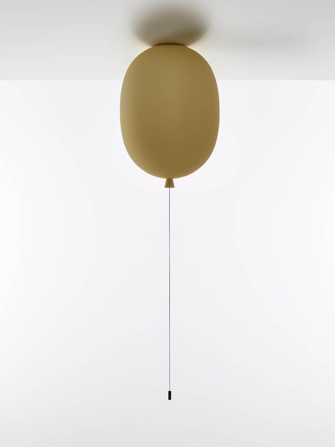 Brokis Memory Ceiling Oval 350: a brown, glass fitting graces a white ceiling; slender black string completes the luxe look.