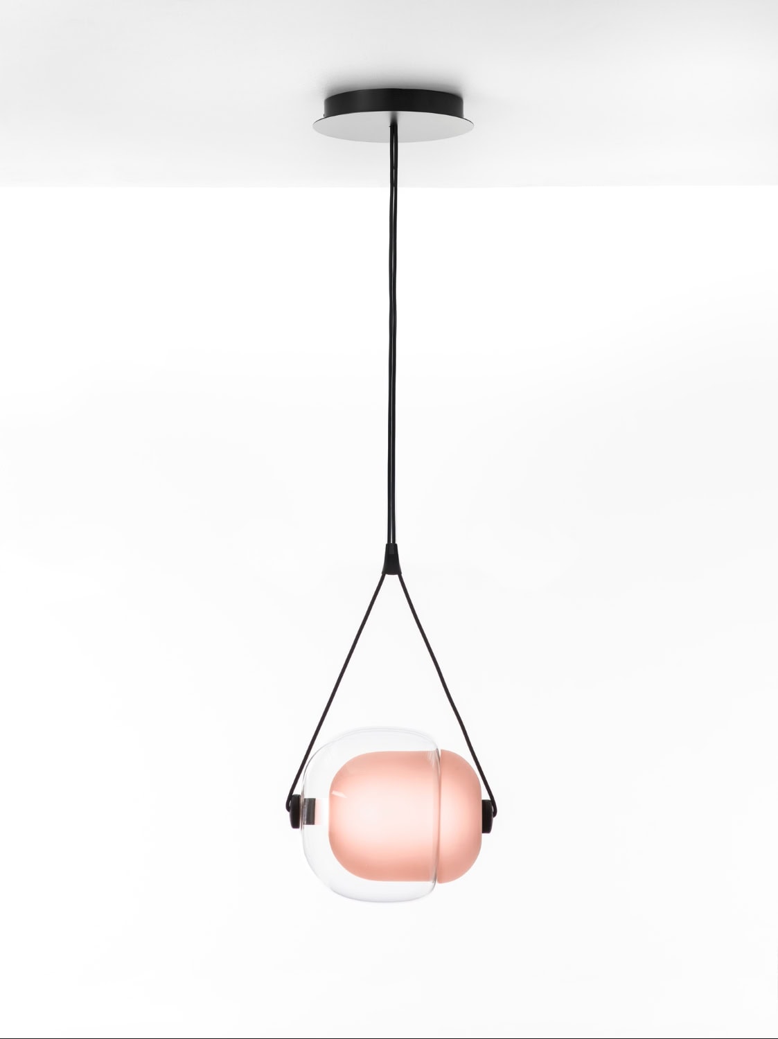 Brokis Capsula Single Pendant, with handblown glass and a light pink core, is suspended by black supports in luxe minimalism.
