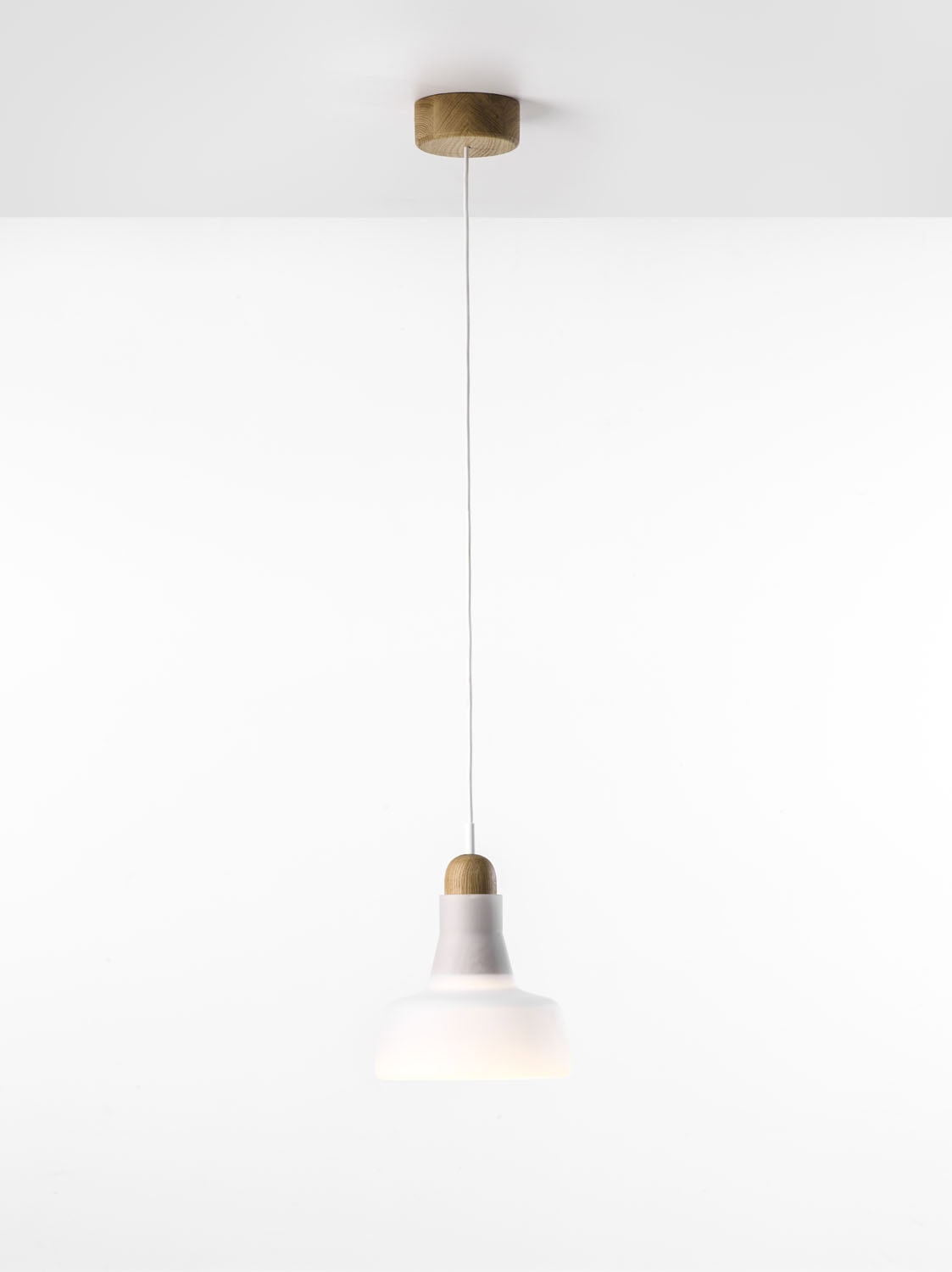 Shadows XL Small Pendant by Brokis exudes luxury with an opaline glass shade, slim flex, and sculpted wooden accents.