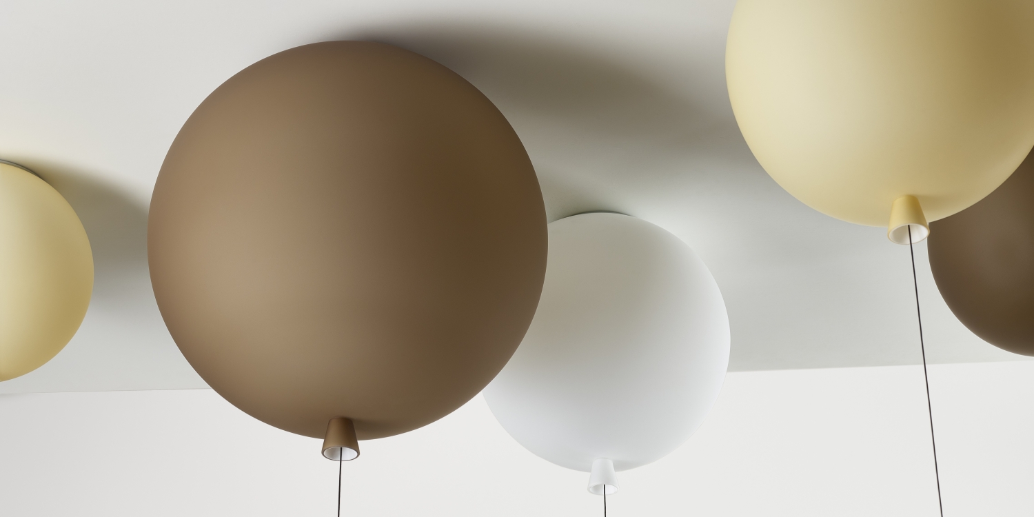 A close up of Brokis Memory ceiling lights in handblown brown, white, and amber glass with a matt finish, viewed from below.