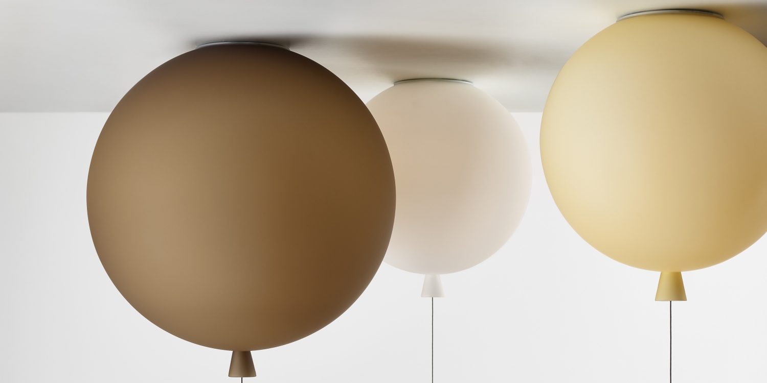 Brokis Memory celing lights in brown, white, and amber float playfully beneath a pristine white ceiling.