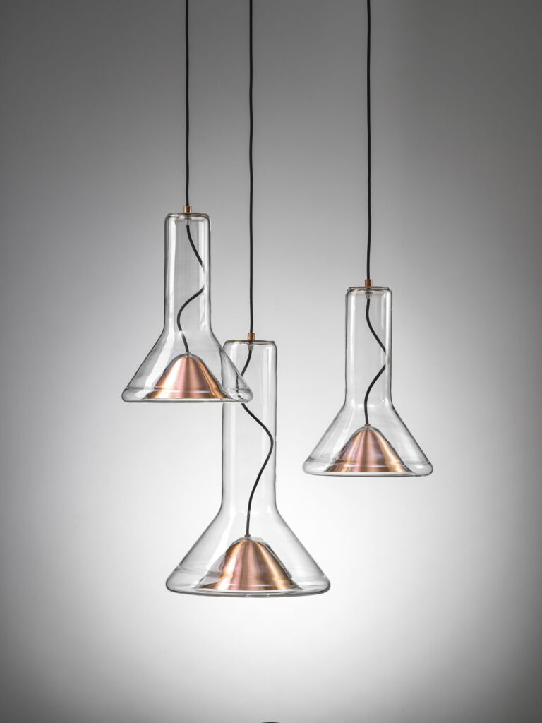 Brokis Whistle Set SSM pendant lights hang at varied heights with sleek flask-shaped shades.