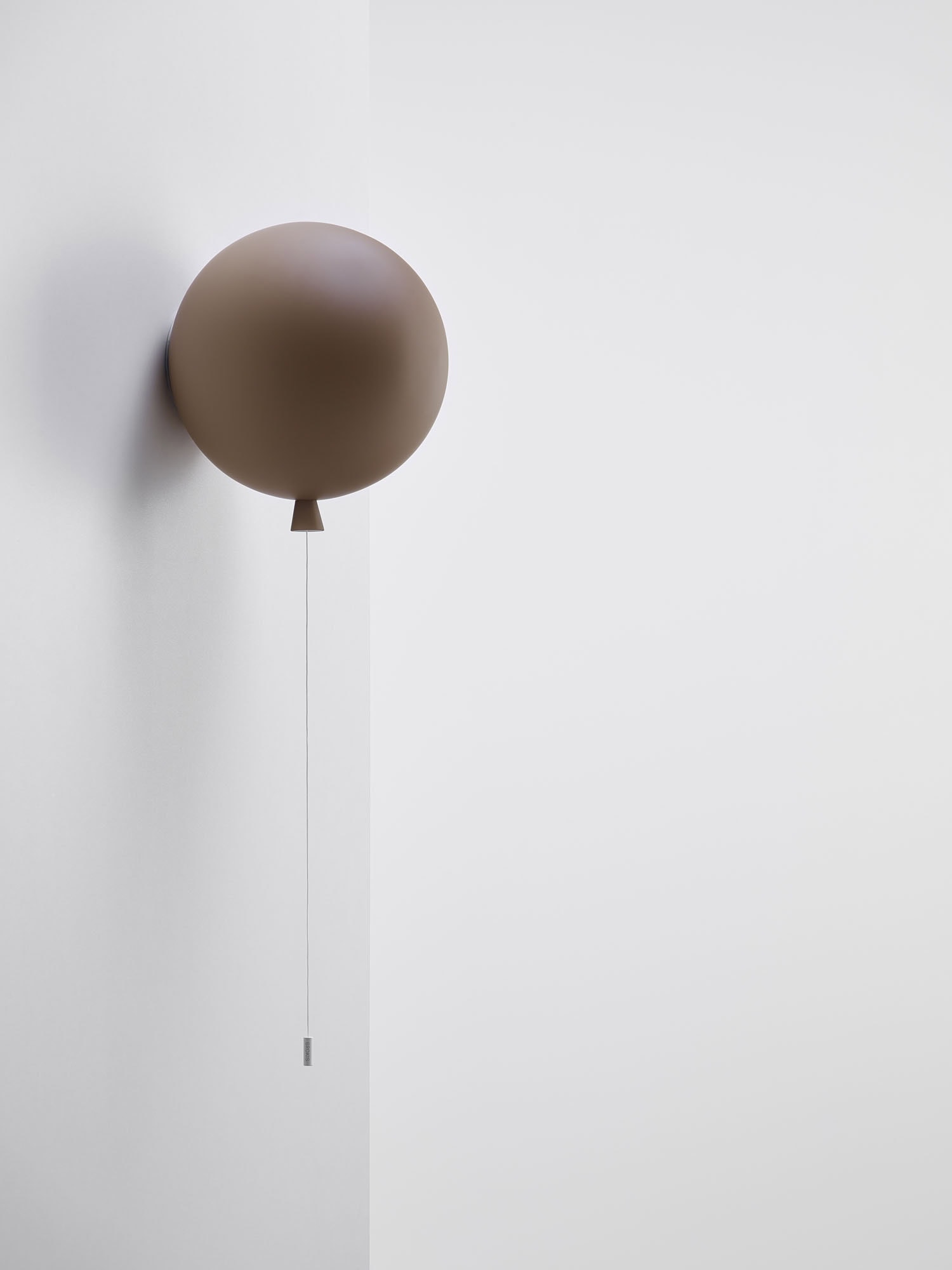 Brokis Memory Wall 250 lamp floats balloon-like on a white wall, accented by a delicate pull cord.