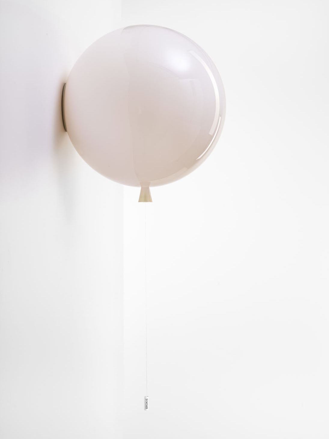 Brokis Memory Wall 400 in light pink graces a white wall, softly lit for an elegant, minimal effect.