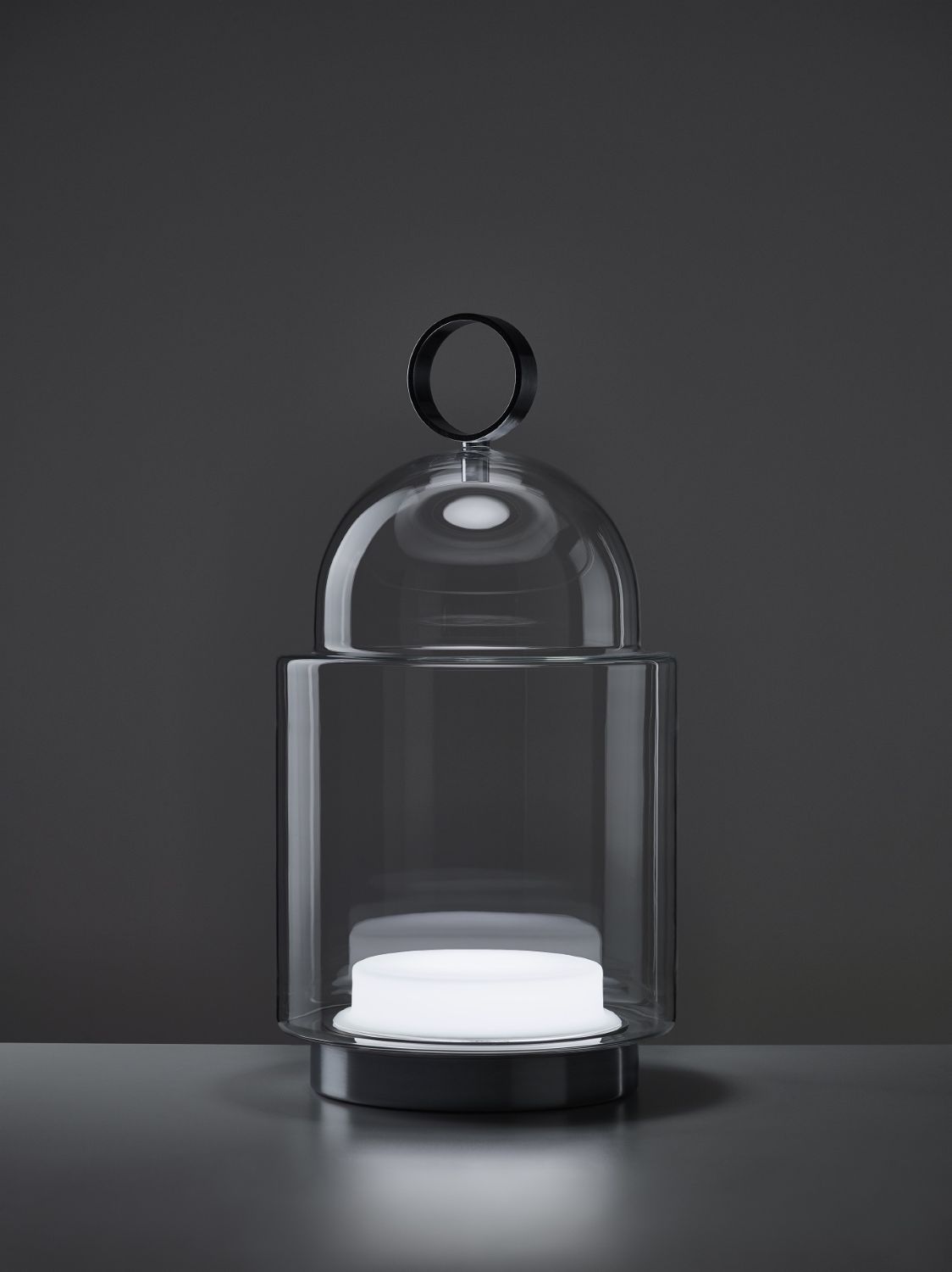 Brokis Dome Nomad Large: a handblown glass lantern with sculptural curves, glowing softly against a smooth grey backdrop.