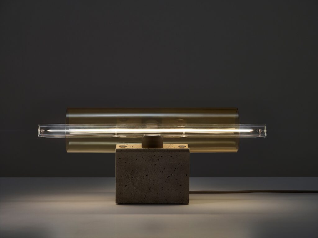 Brokis Overlay Table M boasts a sculpted concrete base, handblown amber glass shade radiating soft luxe light.