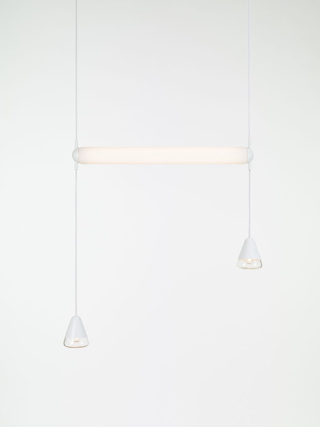 Brokis Puro Single Horizontal 800 Pendant: a sculptural, handblown glass tube with cone accents on slender white flexes.