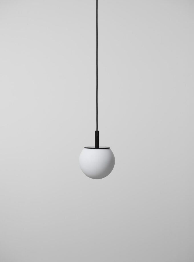 Brokis Sfera 180 Pendant, a sculptural hand-blown white sphere, floats from a black cord against an elegant grey backdrop.