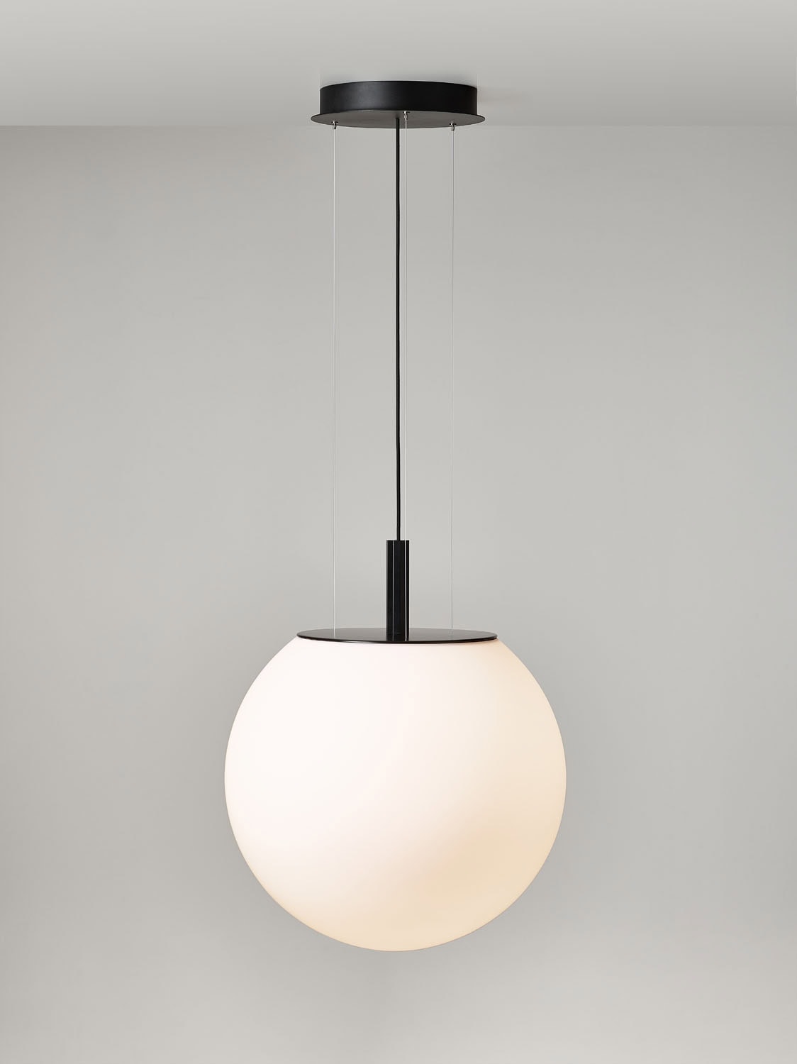 Brokis Sfera 600 Pendant: a sculptural frosted glass globe, suspended by black cords from a sleek black ceiling rose.