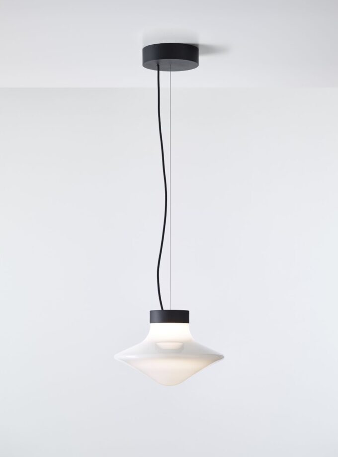 Brokis Trottola Pendant S features a sculptural, curved glass shade that casts a soft, luxurious glow from a black mount.
