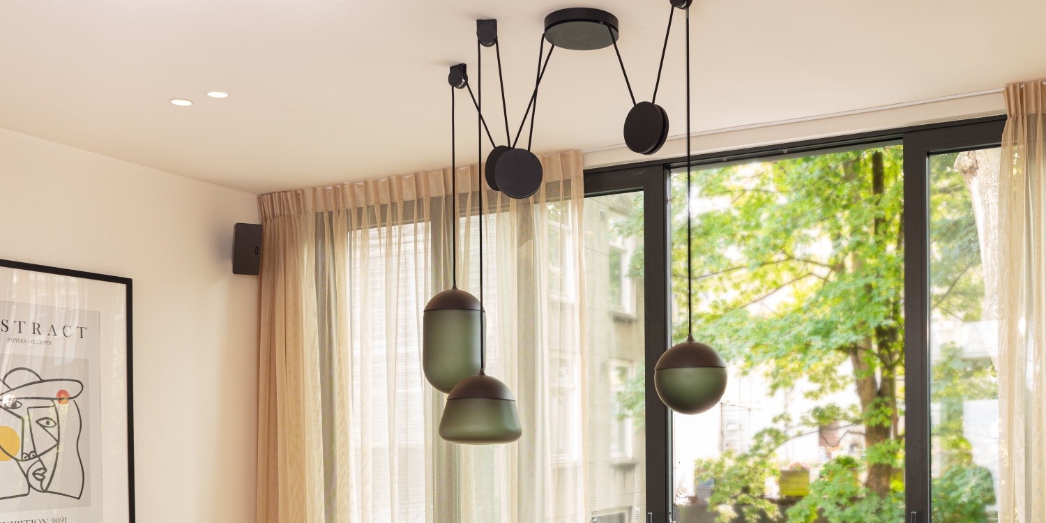 Brokis Planets 3 Set in a modern living room boasts sheer beige curtains, and floor-to-ceiling windows.