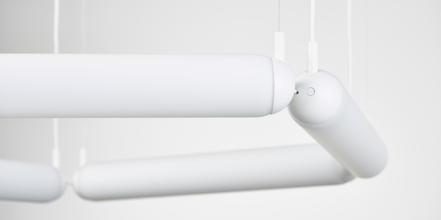 Close-up of the sculptural handblown Brokis Puro Contour Pentagon chandelier, its white tubes suspended elegantly.