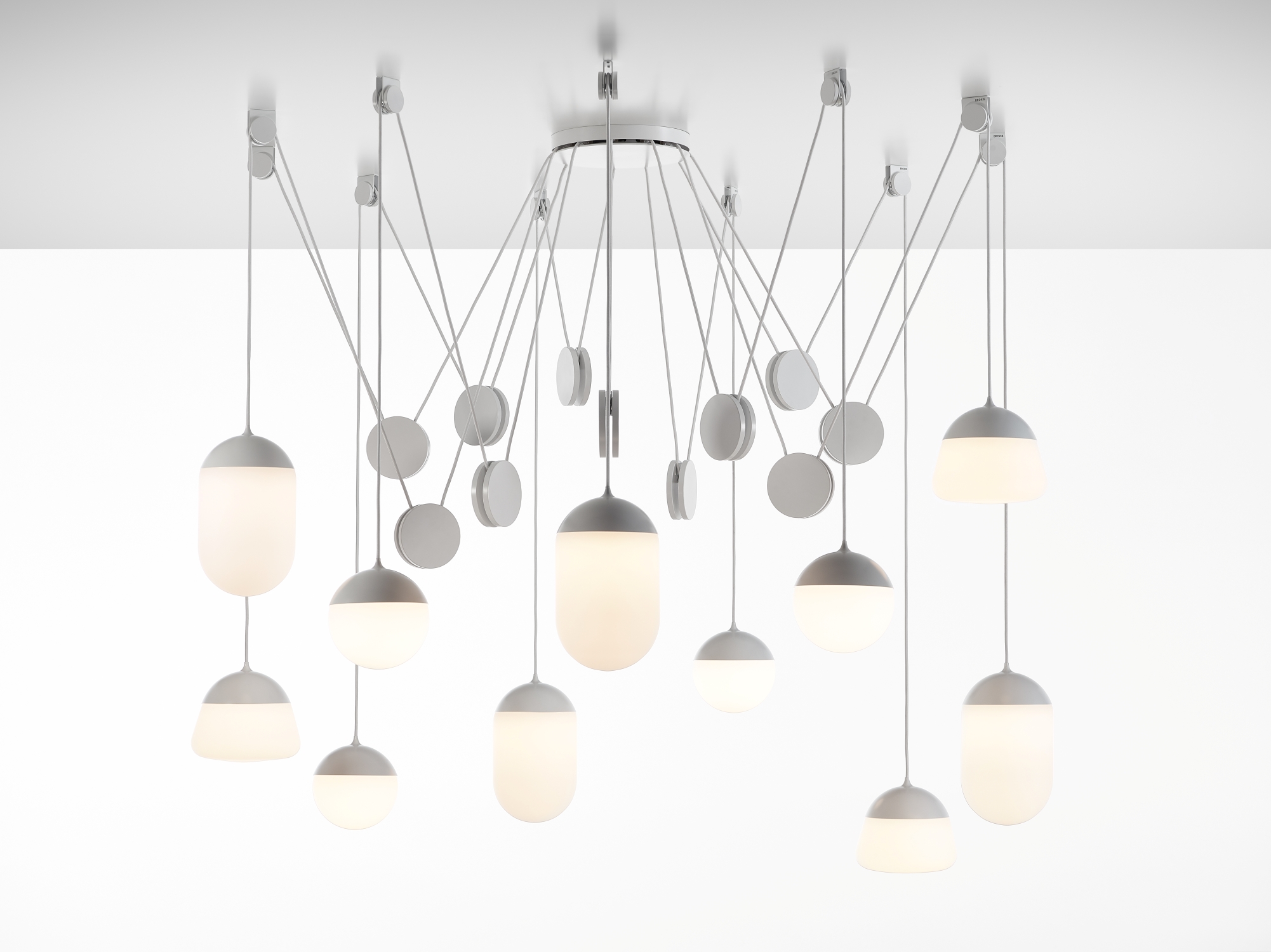 Brokis Planets 11 Set showcases sculptural, hand-blown glass lights in white, gracefully suspended at varied heights.