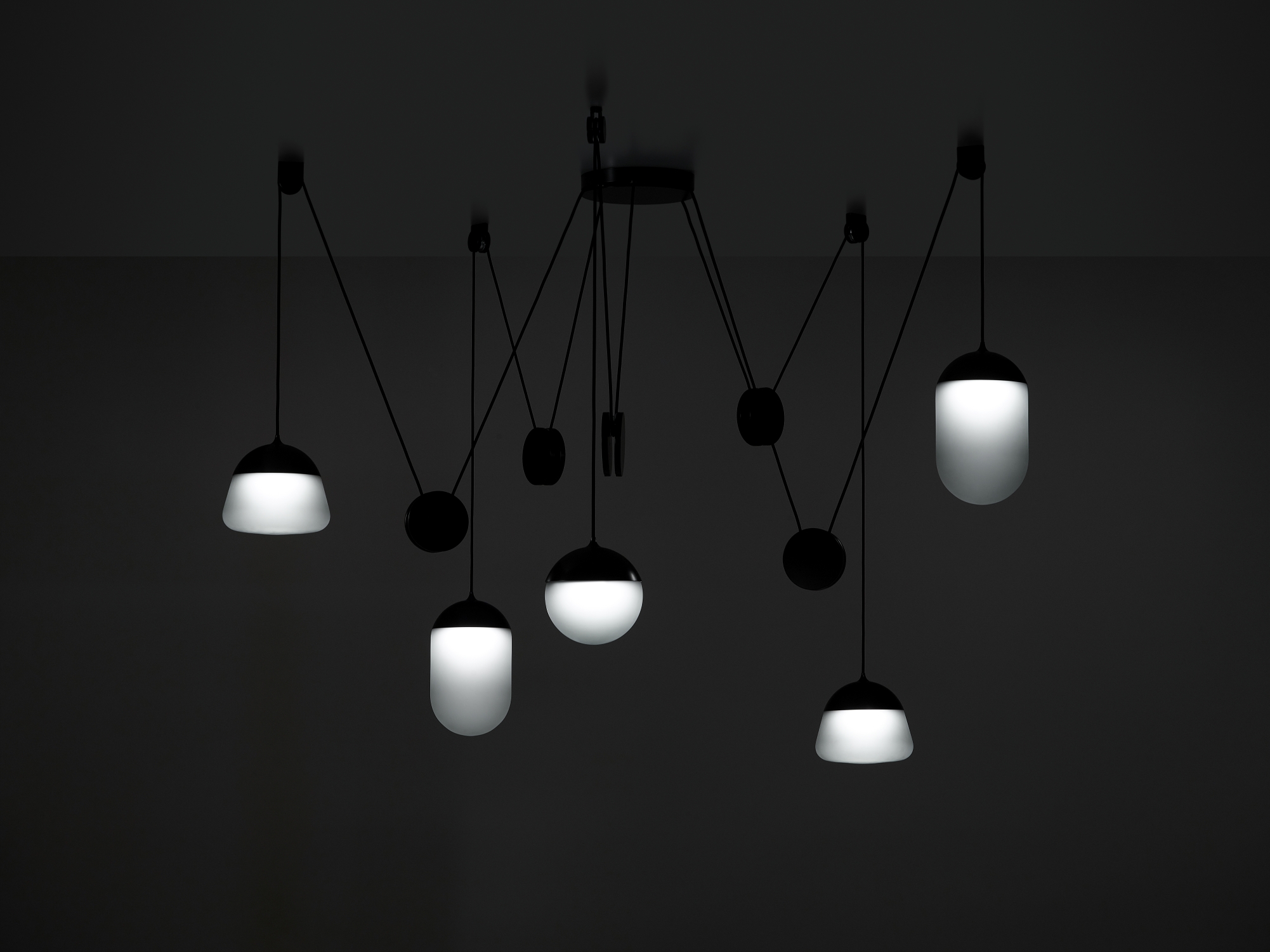 Brokis Planets 5 Set showcases five hand-blown domes on black cords, glowing softly in sculptural elegance.