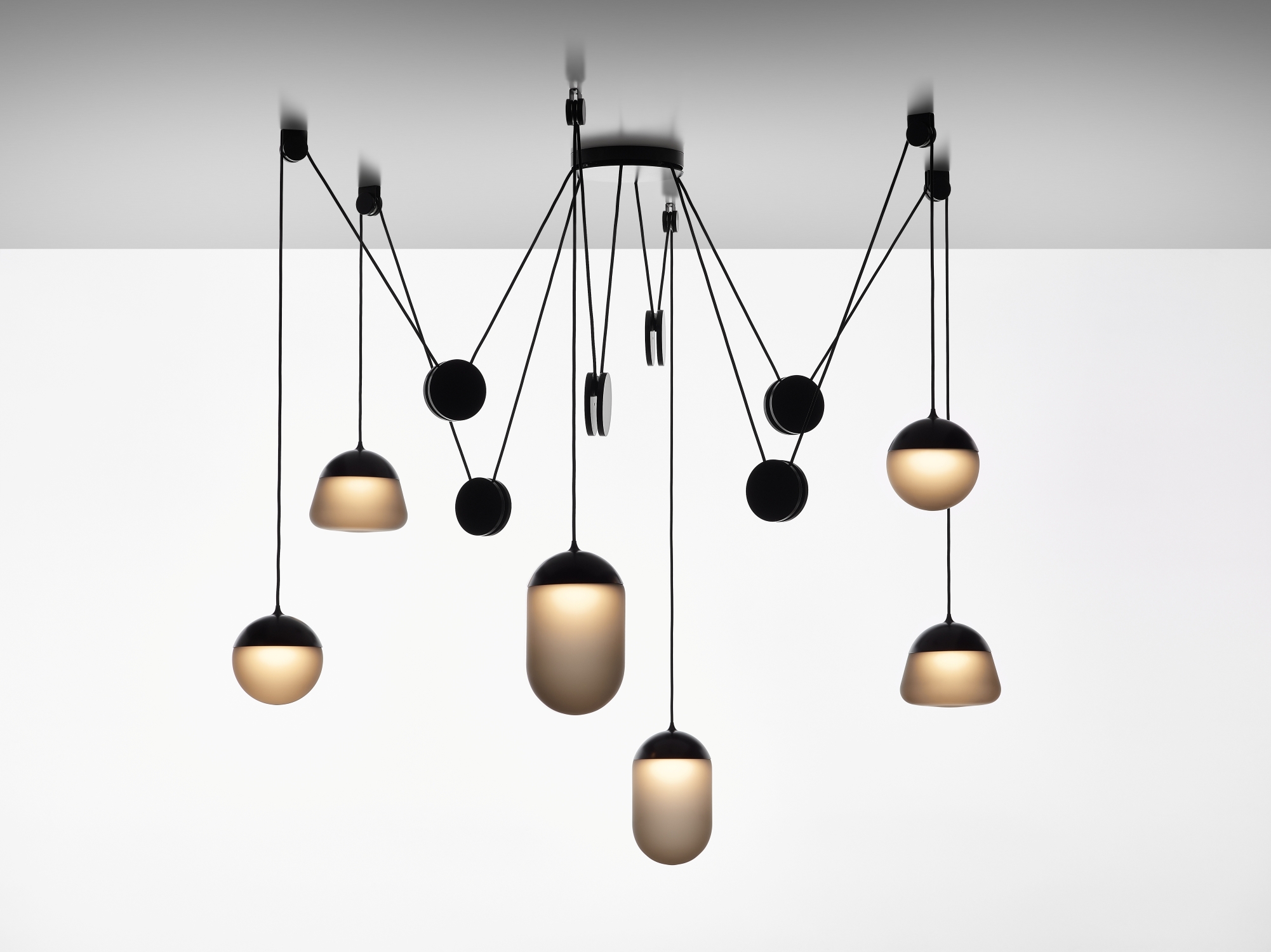 Brokis Planets 6 Set: smoke grey glass lights cascade at varied heights from black cords, exuding sculptural luxury.