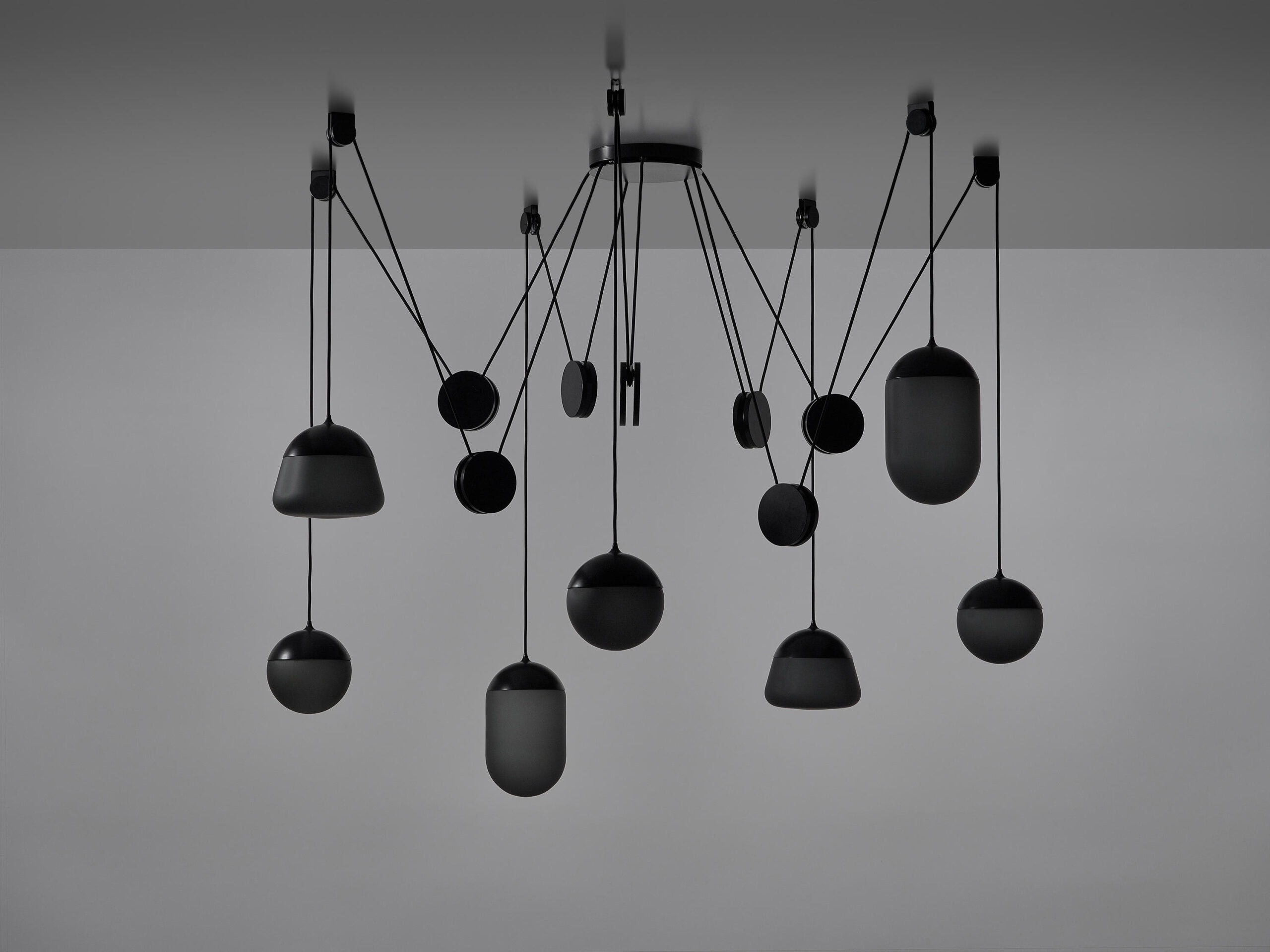 Brokis Planets 7 Set showcases sculptural black pendants, handblown glass forms suspended on bold geometric cords.