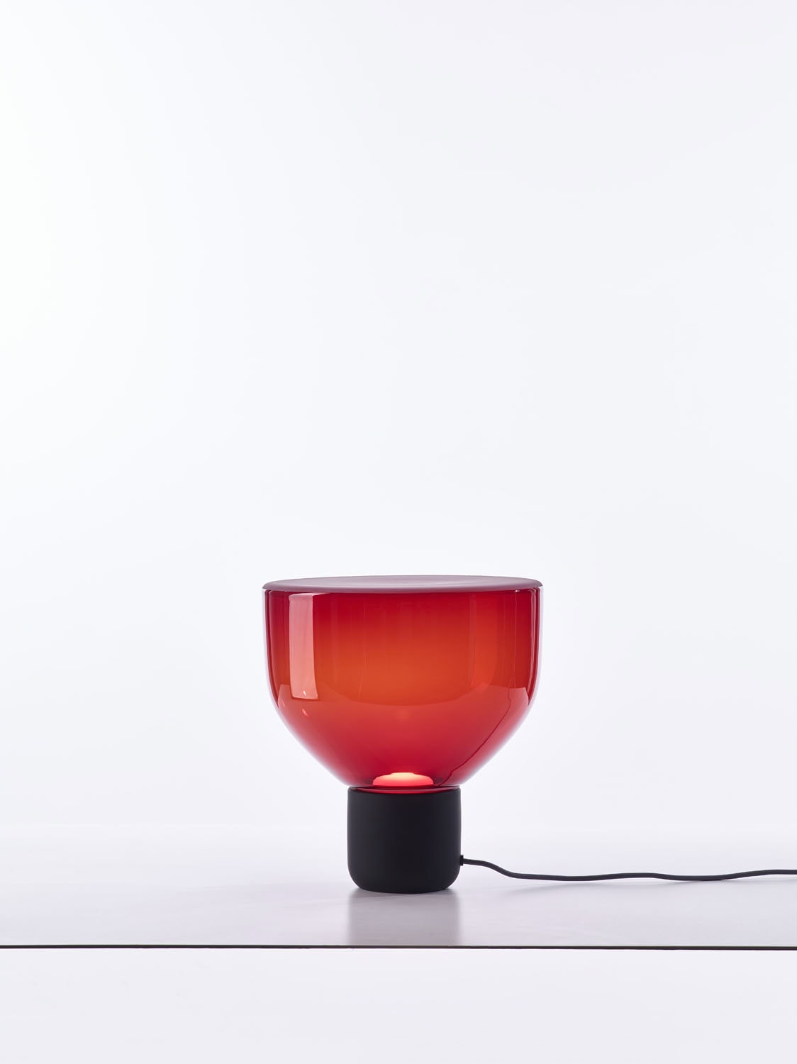 Brokis Lightline S Table is a sculptural red handblown glass lamp with a refined sleek black base.