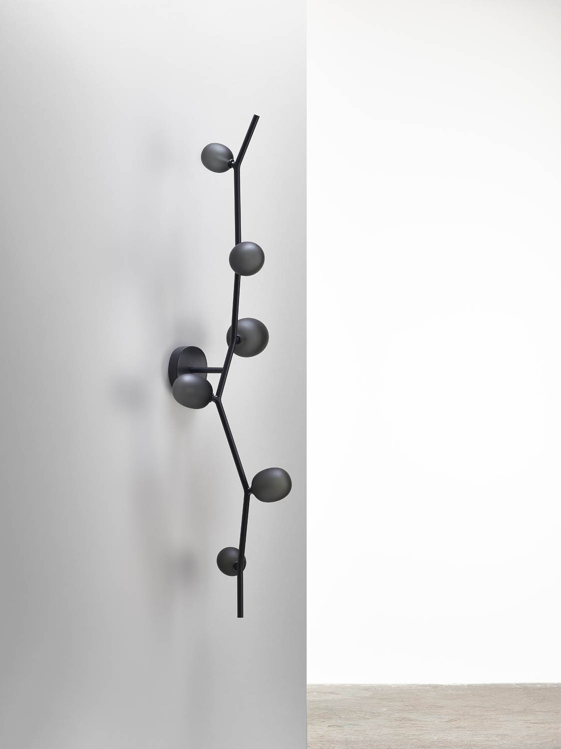 Brokis Ivy Wall 6: a sculptural black metal fitting with six hand-blown glass bulbs on a pristine white wall.