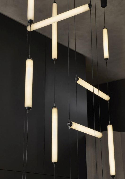 Brokis Puro Single Vertical pendants in sculptural frosted glass cascade at varying heights, exuding modern luxury.