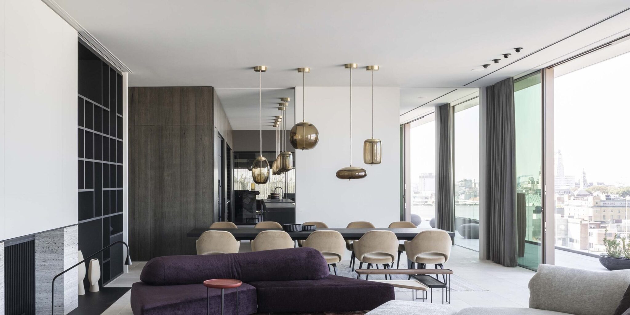 Opulent open-plan living-dining space with floor-to-ceiling windows, deep purple sofa, and Brokis Knot pendant lights.