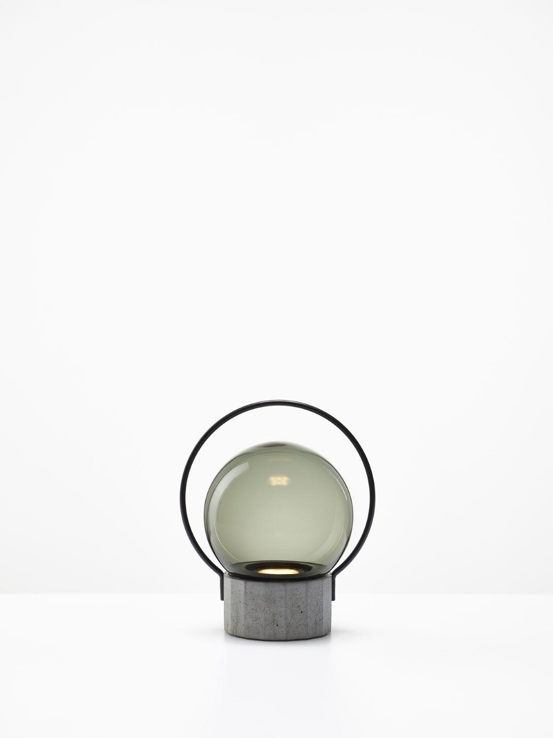 Brokis Sfera Portable Small lamp with a handblown grey glass globe and concrete base, draped by a sleek black metal handle.