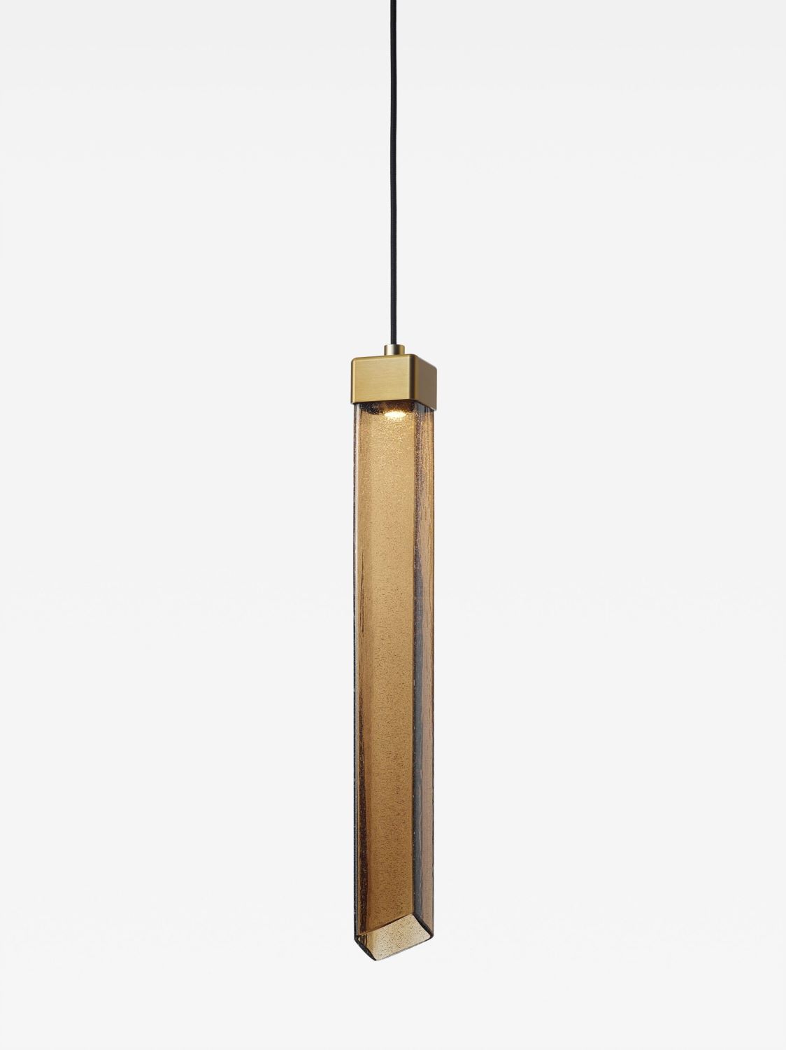 Brokis Comet Square 580 pendant with sculptural brown glass and a brass cap suspends elegantly on a black flex against white.