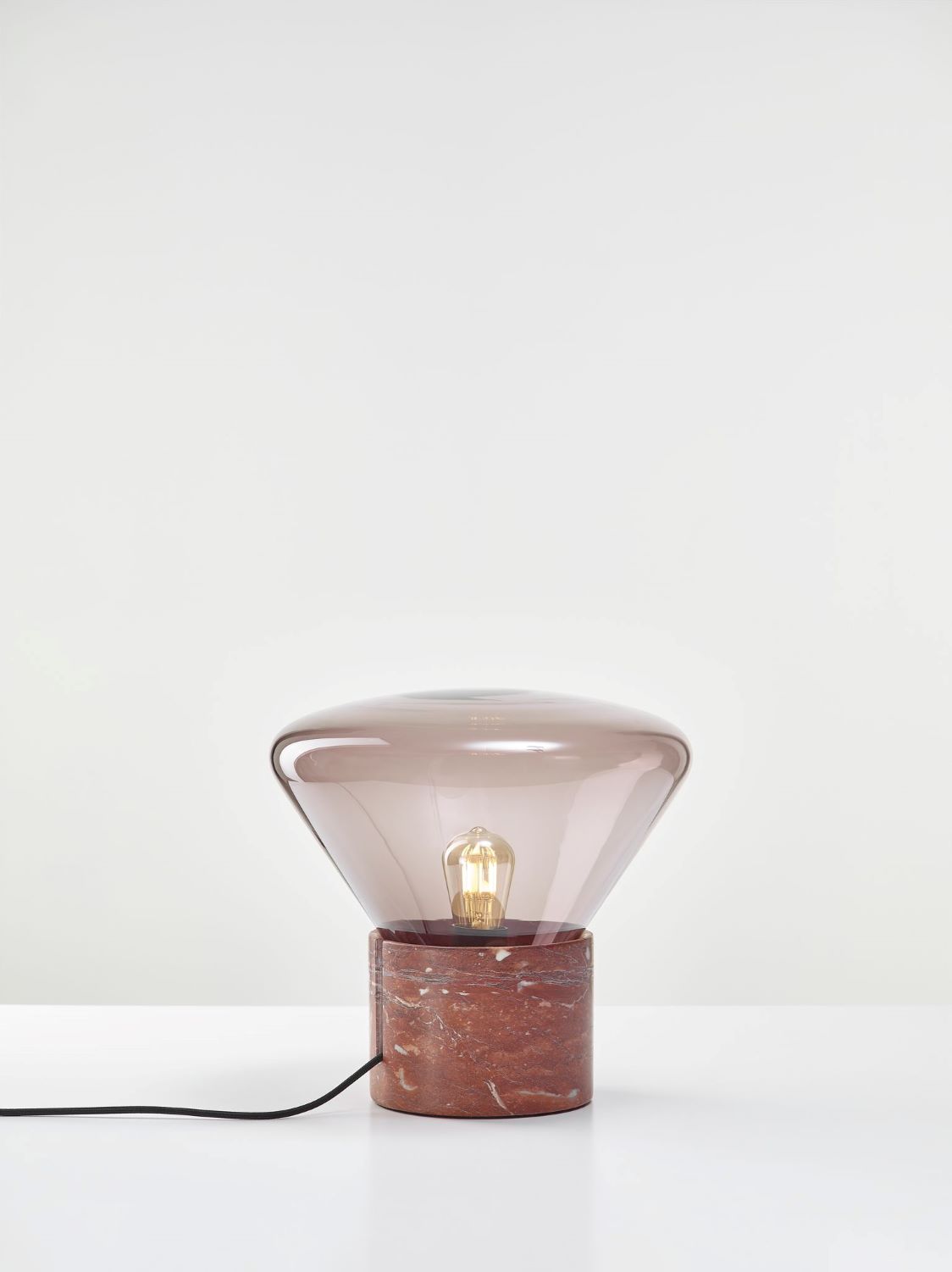 Brokis Muffins Wood 01 Table lamp features a red marble base and hand-blown violet glass dome atop a white surface.