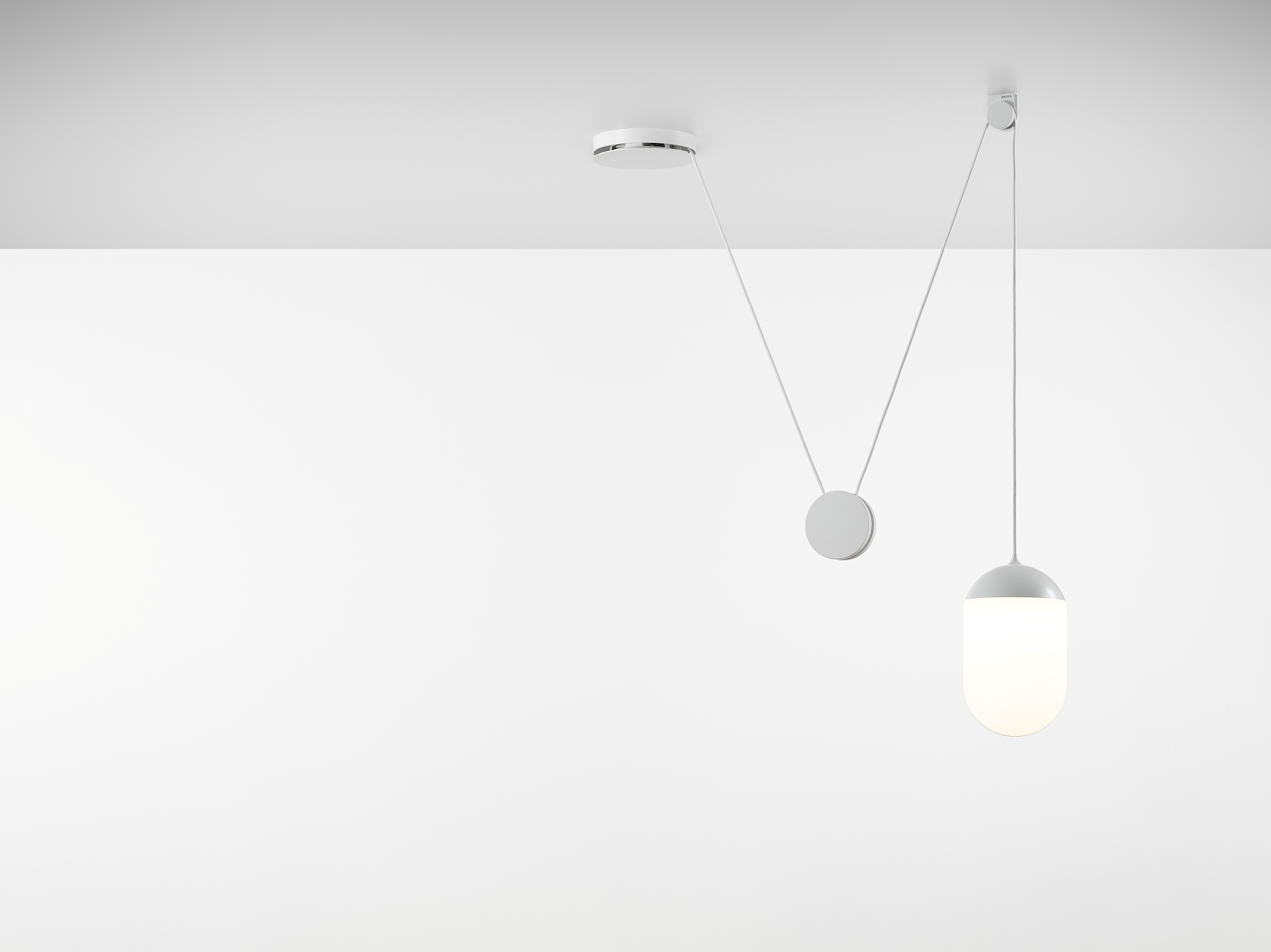 Brokis Planets 1 Set: handblown triplex opal glass light glows softly, suspended by elegant cords against white.