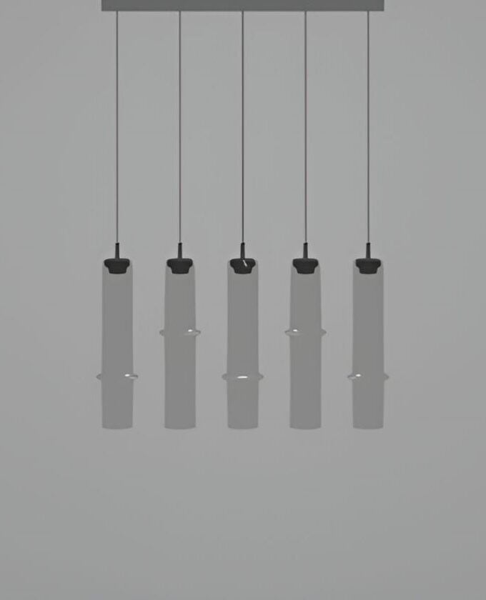 Five Brokis Bamboo Forest R5B pendant lights, hand-blown with sculptural black caps, glow in a sleek minimalist row.