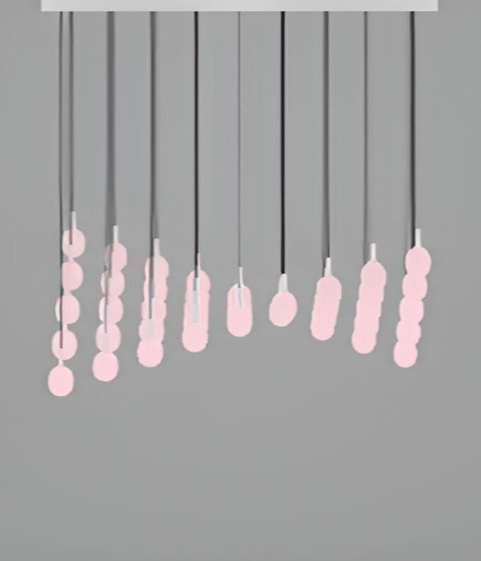 The Bamboo Forest C6C minimalist mobile showcases ten sculptural black rods with pink ovals, suspended from a sleek white base.