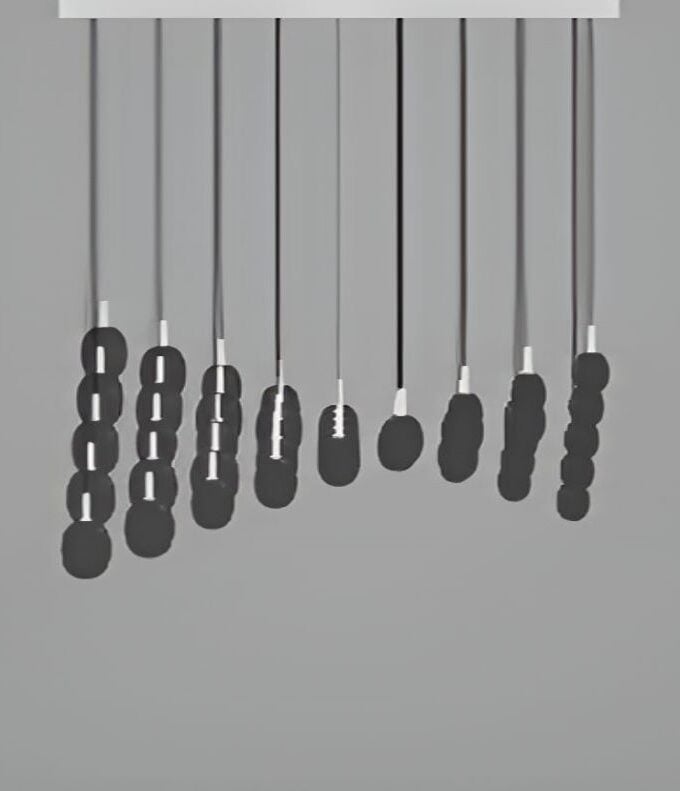 Sculptural Ivy Single S45B pendants by Brokis in handblown crystal hang at varying lengths from a white bar against grey.