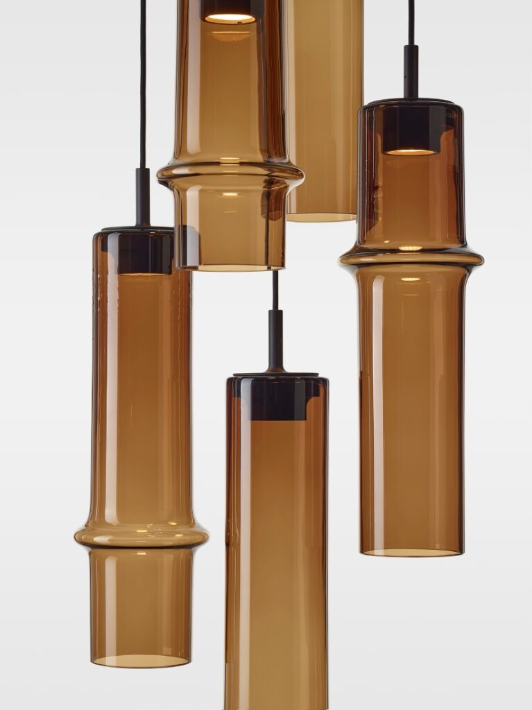Brokis Bamboo Forest pendants with handblown brown glass hang at varying heights, exuding refined modern luxury.