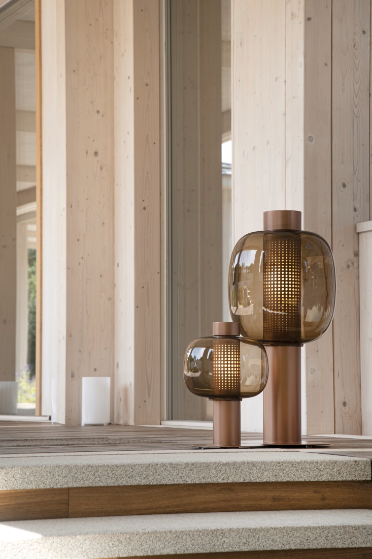 Brokis Bonbori Outdoor lanterns with brown glass and copper bases grace pale wood steps in luminous, serene minimalism.