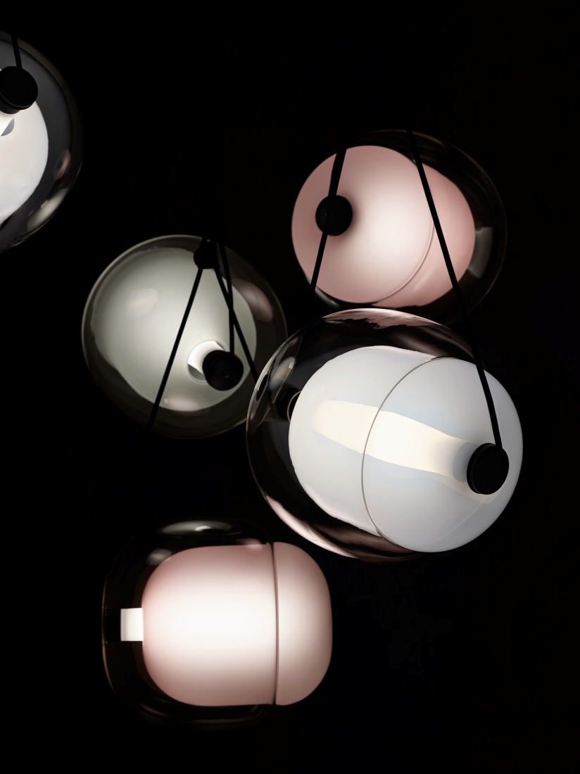 Brokis Capsula Set Metal Canopy with frosted glass shades cast a soft pink and white glow against a dramatic dark background.