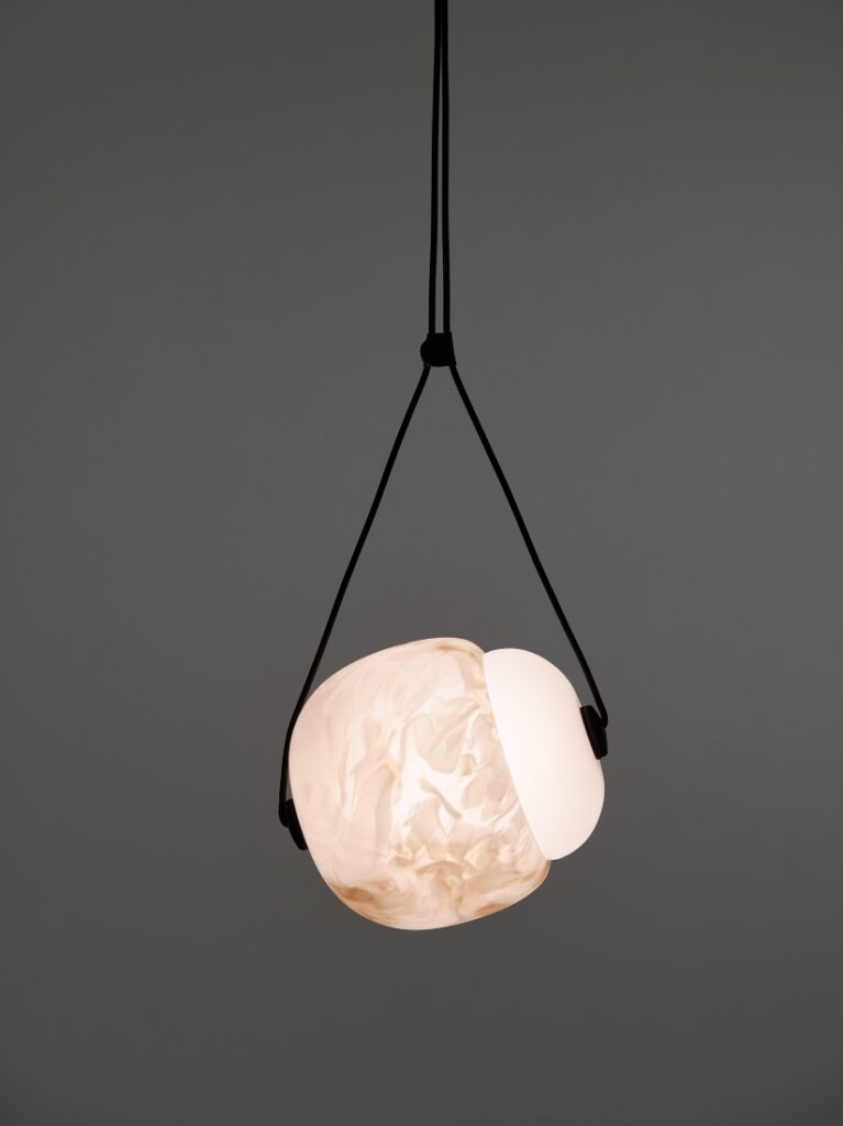 A Brokis Capsula Single pendant with a handblown, BROKISGLASS shade, elegantly suspended on twin black cords.