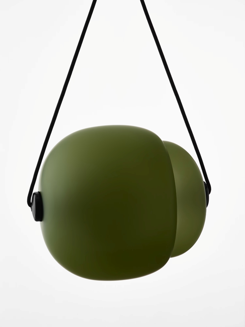 Brokis Capsula Single Pendants in handblown olive green glass hangs from a black strap, exuding modern minimalist luxury.