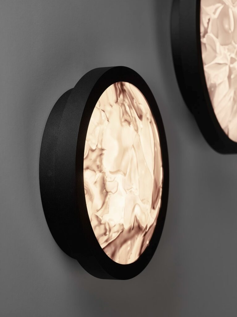 Brokis Convex Applique wall lights with a black frame and wavy crystal diffuser radiates soft, warm luxe light.