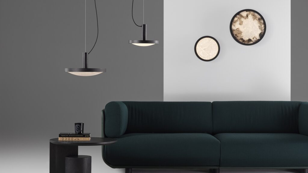 A modern living room with a dark green sofa and Brokis Convex pendants illuminating chic circular wall lights.