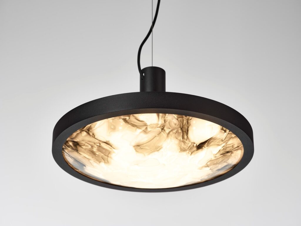Brokis Convex M Pendant with a round black metal frame and BROKISGLASS diffuses warm light in an elegant, soft glow.