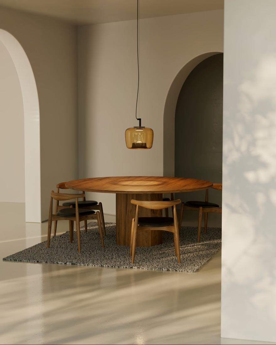 A dining area with a round wooden table, black-seated chairs, textured grey rug, and Brokis Double Medium pendant overhead.