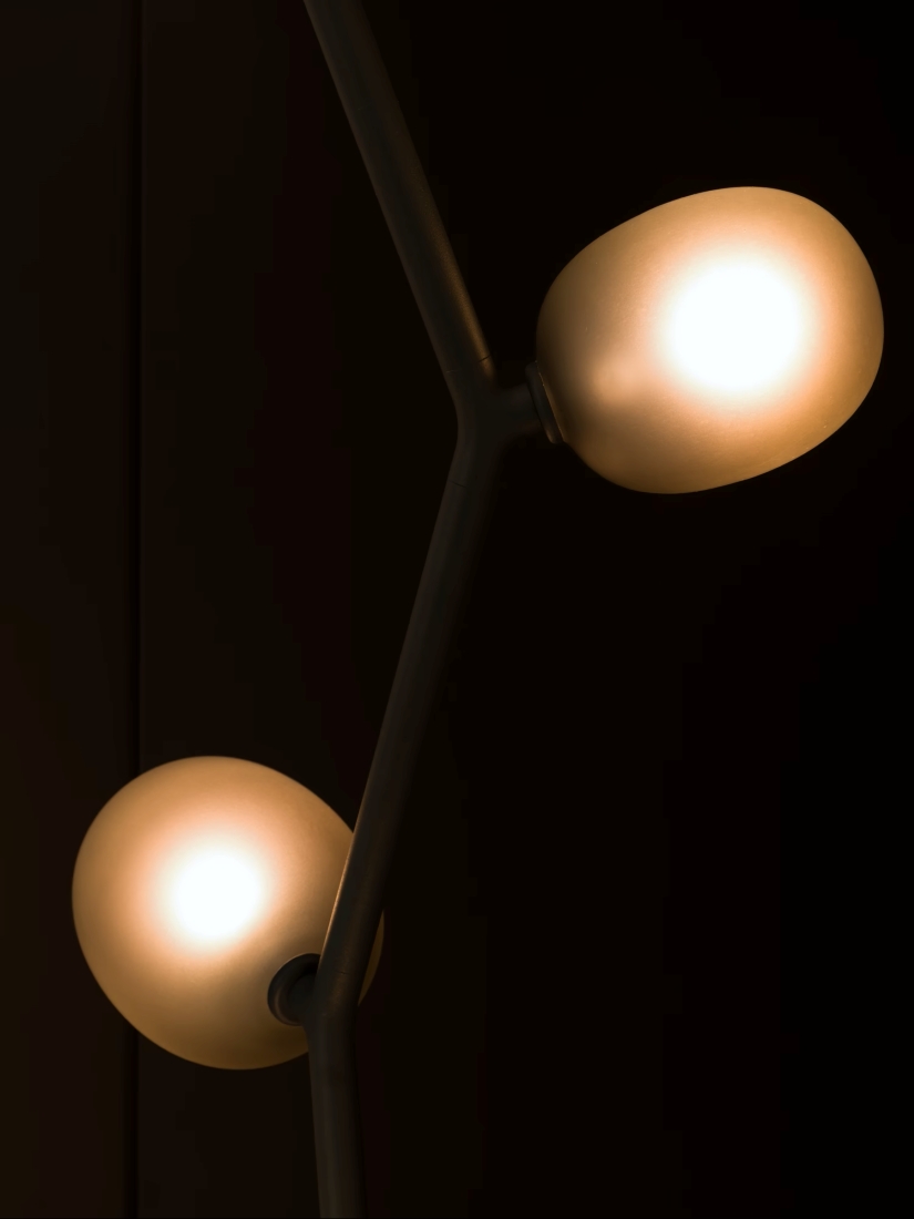 Brokis Ivy Floor with glass orbs on a black metal fitting cast a warm, luxurious glow against a dark backdrop.