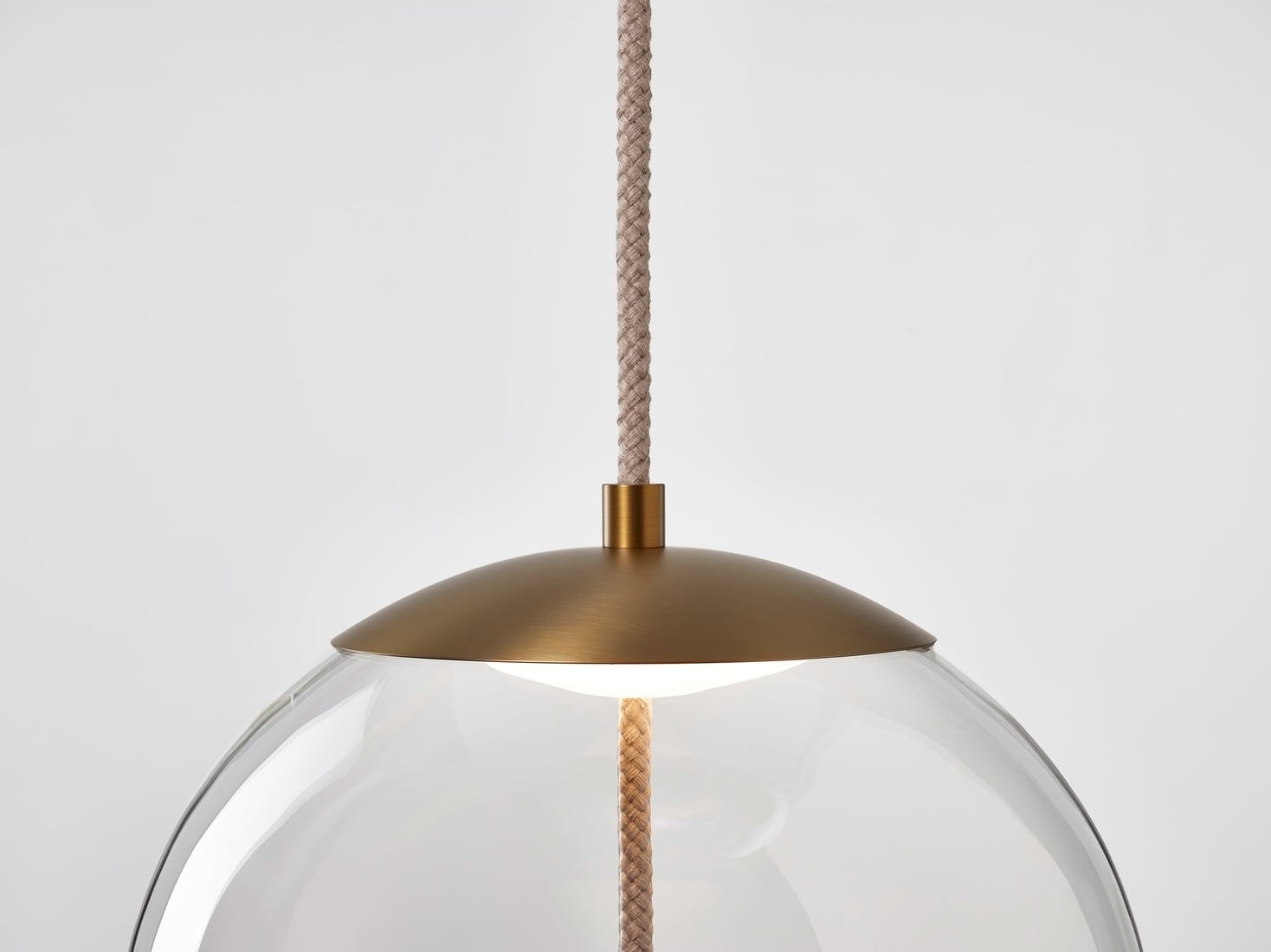 Brokis Knot Sfera Pendant with a handblown glass dome, brass top, and luxe rope cord, set against a white background.