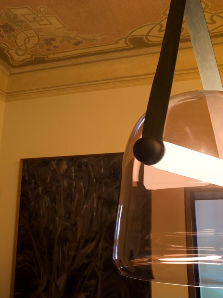 Brokis Mona Large Pendant with a translucent violet glass shade glows amid Art Nouveau floral ceiling designs.