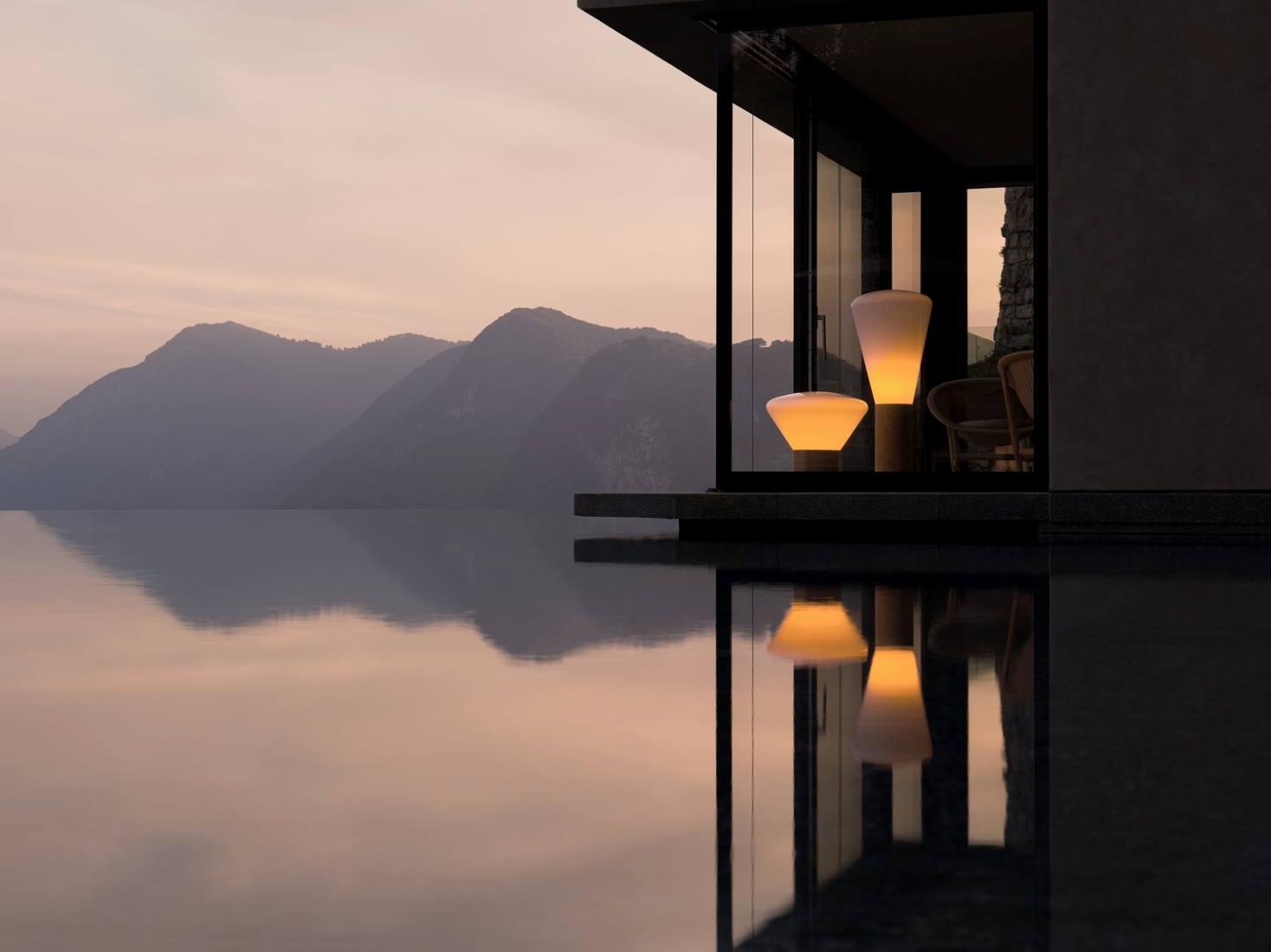 A modern house glows beside a serene infinity pool at sunset, reflecting Brokis Muffins lamps and tranquil pastel mountains.