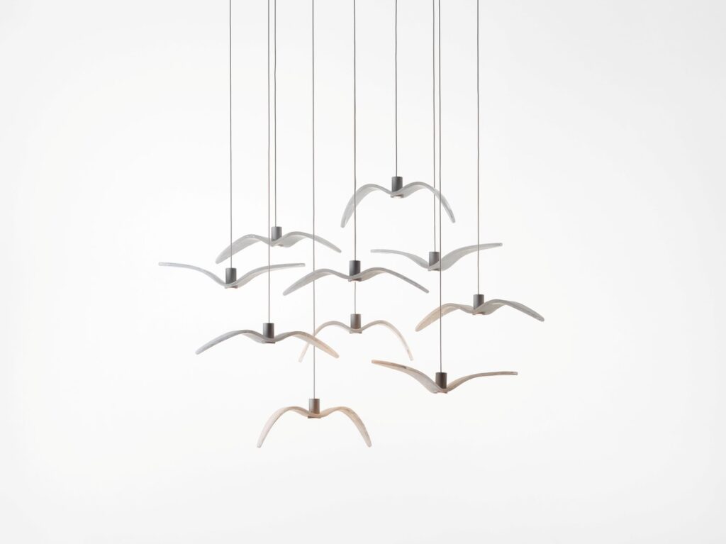 Brokis Night Birds MINI with nine glass  pendants, birdlike and airy, suspended by fine cables against a white backdrop.