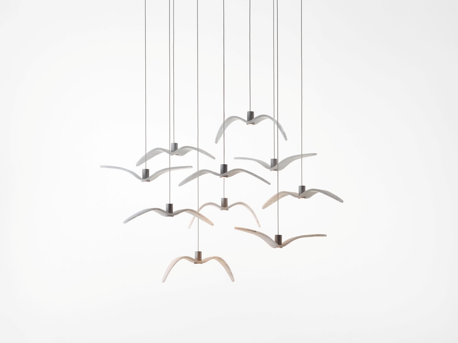 Brokis Night Birds MINI with nine glass  pendants, birdlike and airy, suspended by fine cables against a white backdrop.