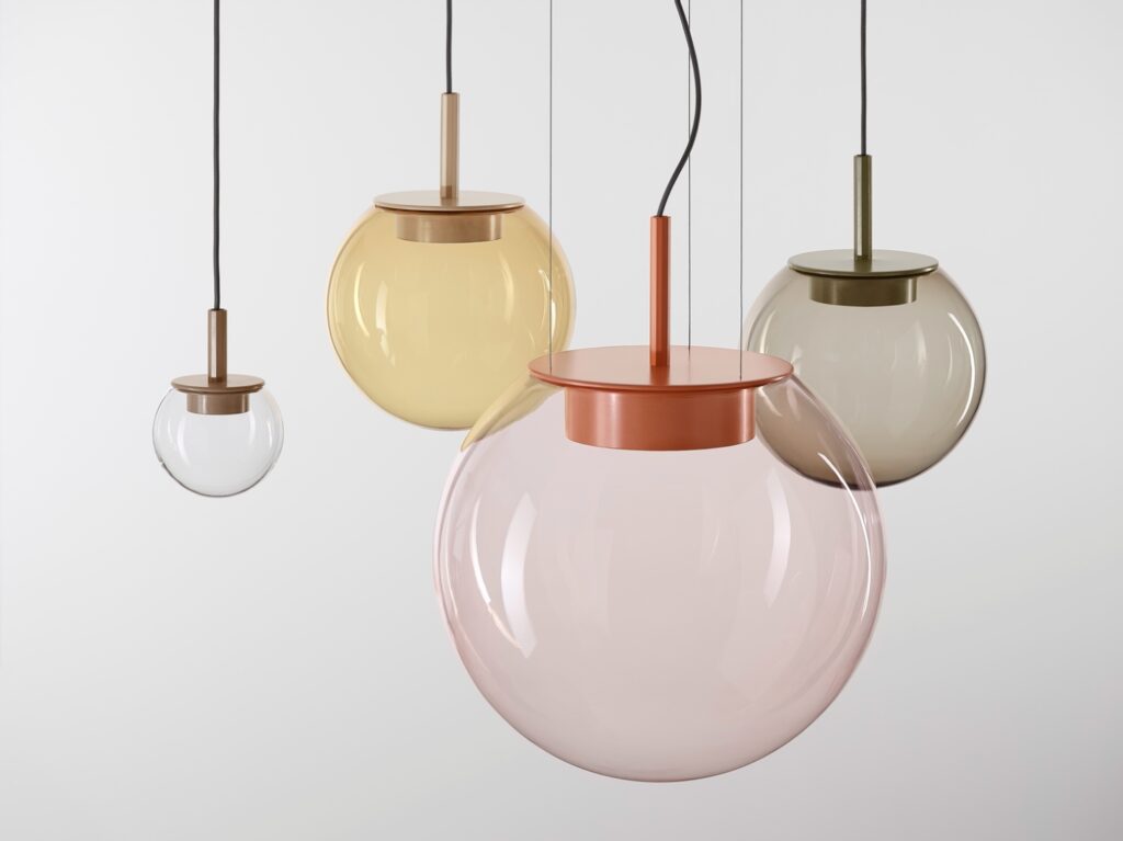 Brokis Orbis pendants with handblown glass spheres in soft hues hang at varied heights on sleek black leads.