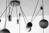 Brokis Planets 6 Set with sculptural black mounts and cords suspends glass orbs in a luxe geometric arrangement.