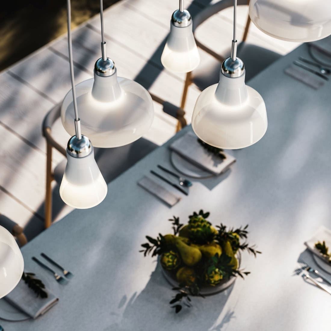 Overhead view of a dining table set, elegant plates gleaming under Brokis Shadows Exterior pendants.